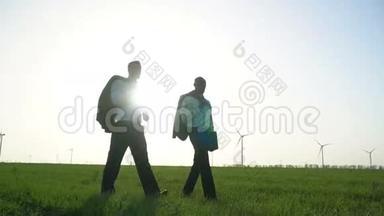 穿着商务服的男人在风力发电机附近的一片绿色草地上行走，其中一个人正在扔出一个